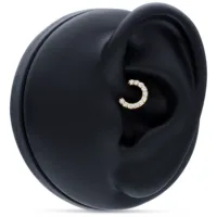 18K Gold Septum Clicker mit Kristallen 18K Gold Septum Ring mit klaren Kristallen auf schwarzem Ohrmodell