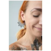 Stylische Abey Hoops aus Edelstahl Nahaufnahme einer Frau mit Abey Hoops Ohrringen, die ein stilvolles Blattdesign zeigen