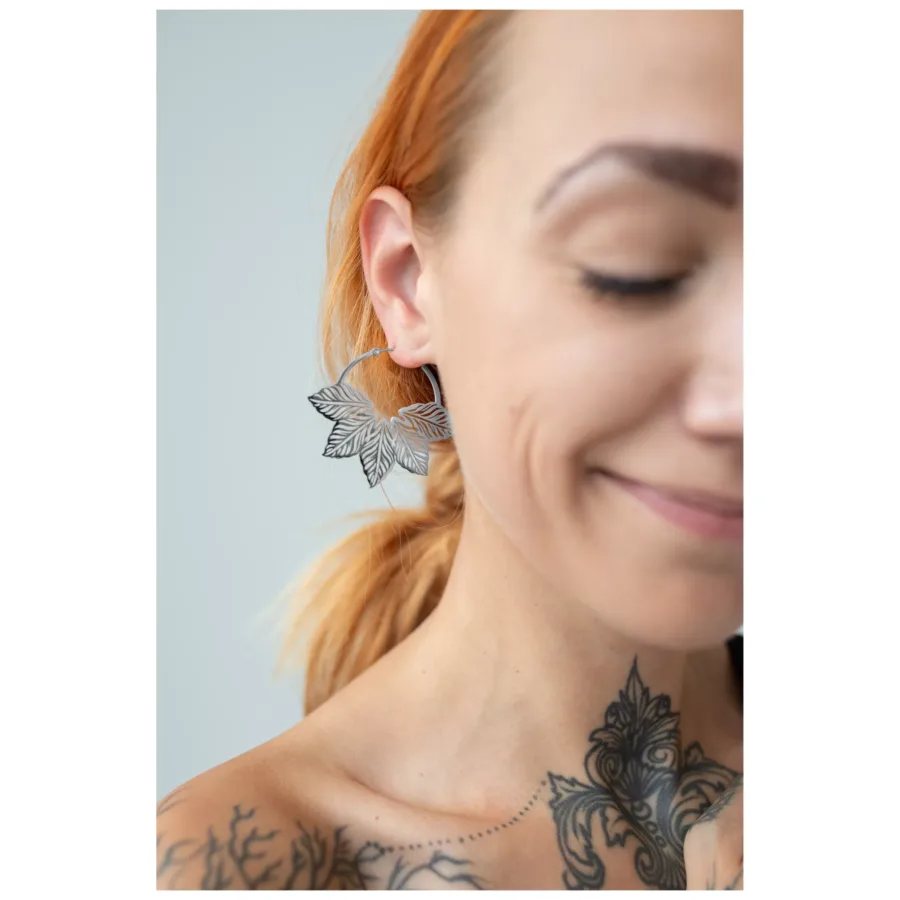 Nahaufnahme einer Frau mit Abey Hoops Ohrringen, die ein stilvolles Blattdesign zeigen