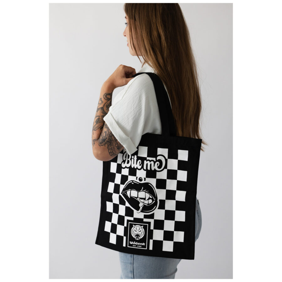 Frau mit schwarzer Baumwolltasche, Schachbrettmuster und 'Bite Me' Schriftzug