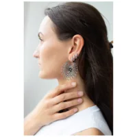 Daisy Hoops Ohrringe in Silber und Schwarz Frau mit Daisy Hoops Ohrringen aus schwarzem und silbernem Chirurgenstahl.