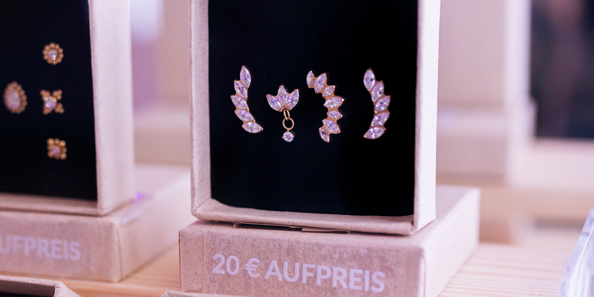 Zwei elegante Ohrstecker mit Kristallen auf schwarzem Hintergrund, 20 € Aufpreis