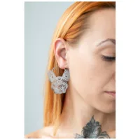Bulldog Hoops Ohrringe in Silber Silberne Bulldogge-Ohrringe am Ohr einer Frau mit hellen Haaren und Tattoo