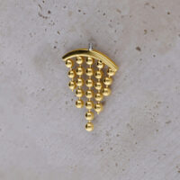Eleganter Goldaufsatz für Helix-Piercing Goldfarbener Helix-Piercing-Aufsatz mit hängenden Kugeln auf hellem Hintergrund