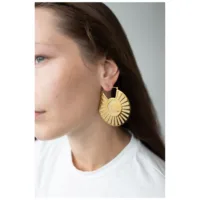 Goldene Moonshine Hoops Ohrringe am Ohr Frau mit langen Haaren trägt goldene Ohrringe in Sonnenform
