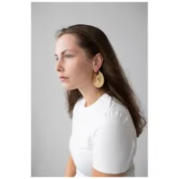 Goldene Moonshine Hoops Ohrringe für Damen Frau mit goldenen Moonshine Hoops Ohrringen vor grauem Hintergrund