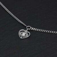 Schlichtes Herz-Augen-Armband aus Silber Silbernes Armband mit Herzanhänger auf schwarzem Hintergrund
