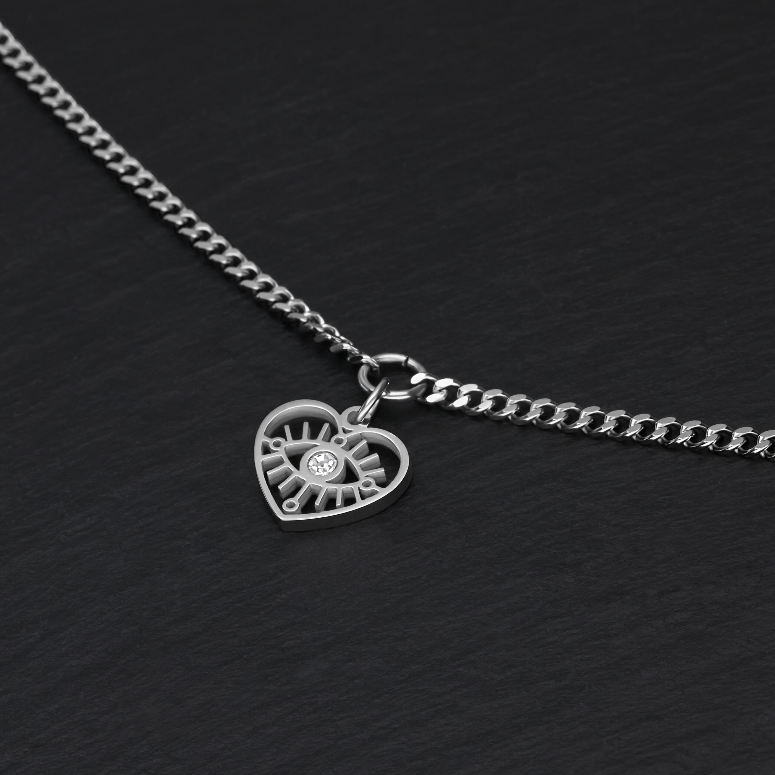 Schlichtes Herz-Augen-Armband aus Silber Silbernes Armband mit Herzanhänger auf schwarzem Hintergrund