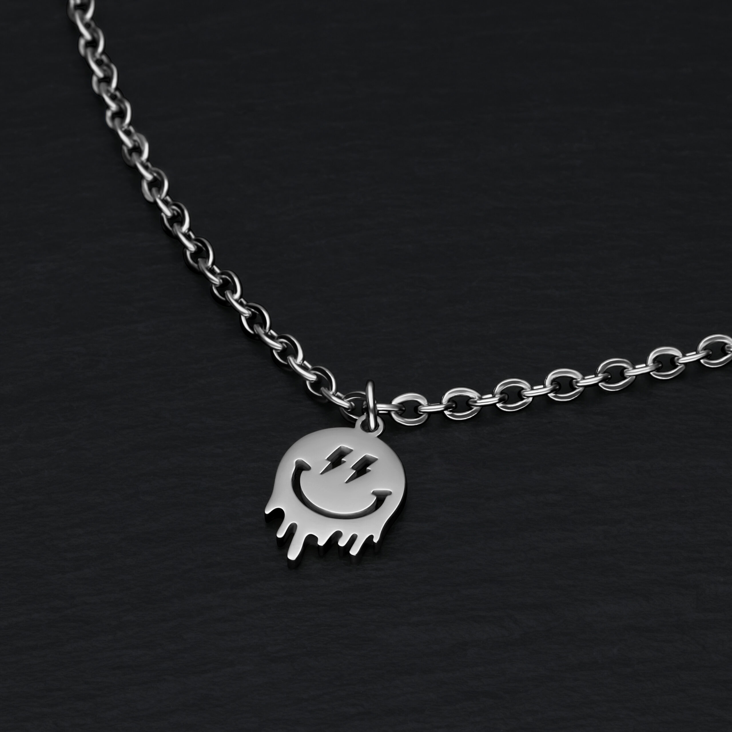 Silbernes Armband mit Smiley-Anhänger auf schwarzem Hintergrund