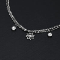 Little Floralis Armband in Silber mit Kristall Silbernes Armband auf schwarzem Hintergrund mit floralen Anhängern und Kristallen