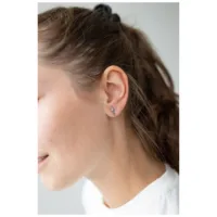 Stylische Schwert Ohrstecker in Silber Silberne Schwert Ohrstecker am Ohr einer Frau vor hellem Hintergrund