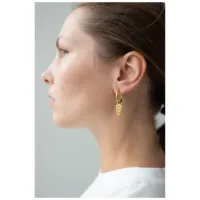 Goldene Little Balisuta Hoops im Profil Frau mit goldenen Little Balisuta Hoops Ohrringen vor neutralem Hintergrund