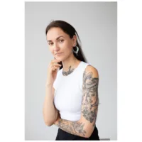 Frau mit Cleopatra Hoops Ohrringen in Silber und Gold auf neutralem Hintergrund