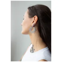 Frau mit langen Haaren trägt silberne Magnolia Hoops Ohrringe