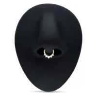 Goldener Septum Clicker mit klaren Kristallen auf schwarzem Hintergrund