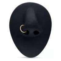 Goldener 18K Rope Piercingring in schwarzer Nase auf weißem Hintergrund