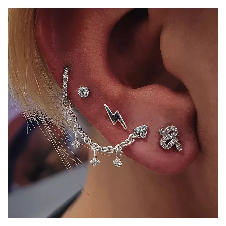 Silberne Piercingkette mit Kristallen an Ohr, glänzend und elegant