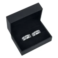 Silbernes Ring-Set in schwarzer Schmuckbox Silberne Ringe aus Chirurgenstahl in schwarzer Box auf schwarzem Hintergrund