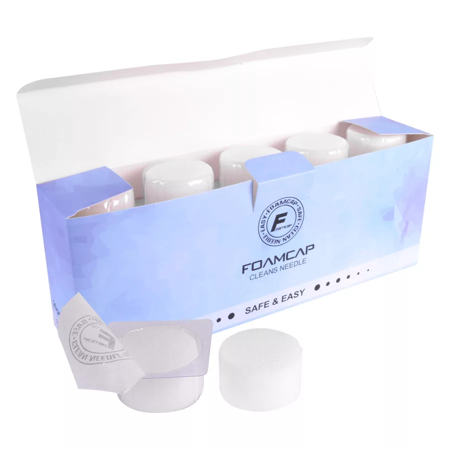 Weiße Foam Caps für Tattoo Zubehör Weiße Foam Caps in blauer Verpackung, geöffnet auf weißem Hintergrund