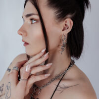 Frau mit silbernen Big Snake Hoops Ohrringen, seitliches Profil