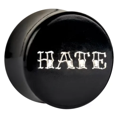 Schwarzer Plug mit weißem 'HATE' Schriftzug auf glänzendem Hintergrund