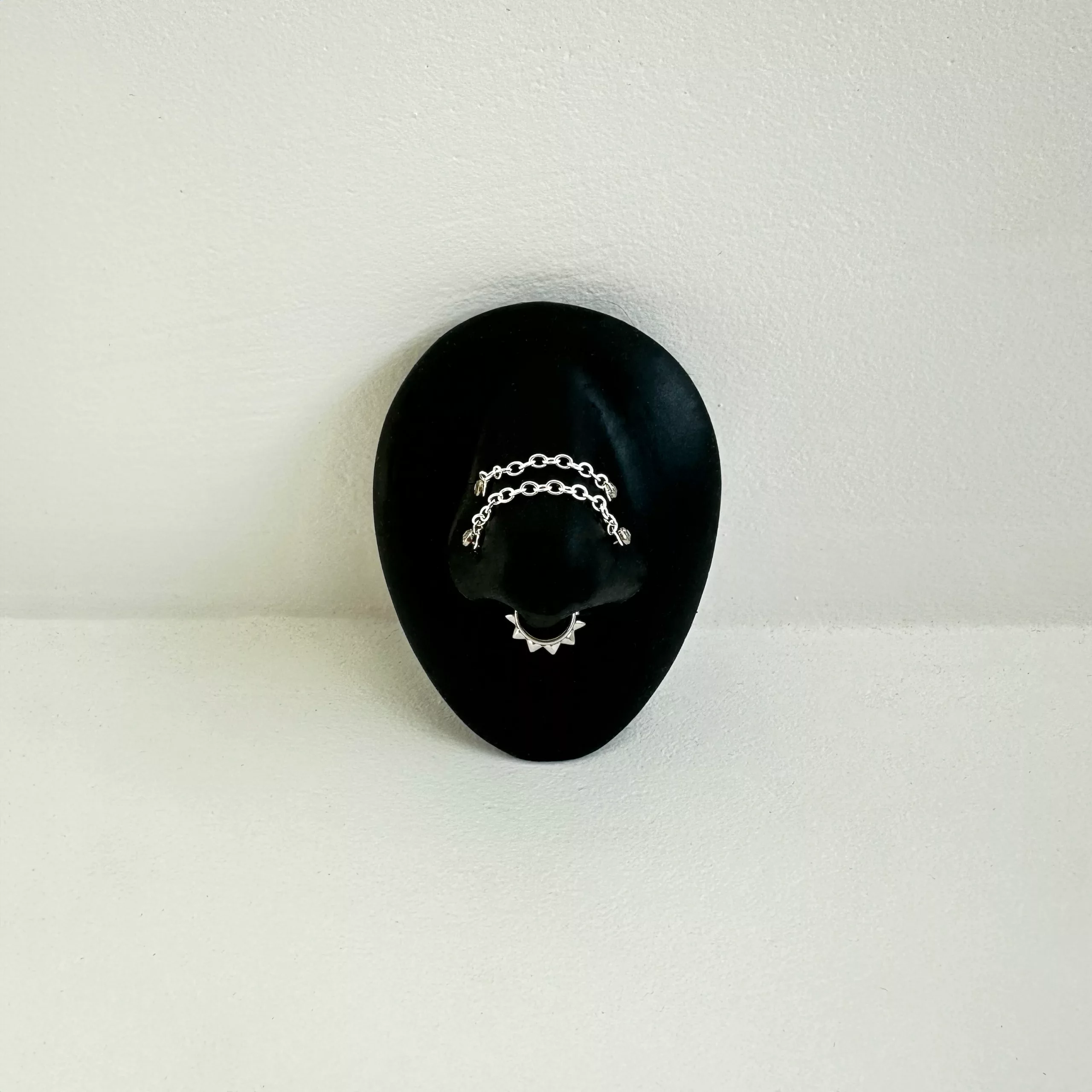 Silberne Piercingkette von Wildcat auf schwarzem ovalem Display