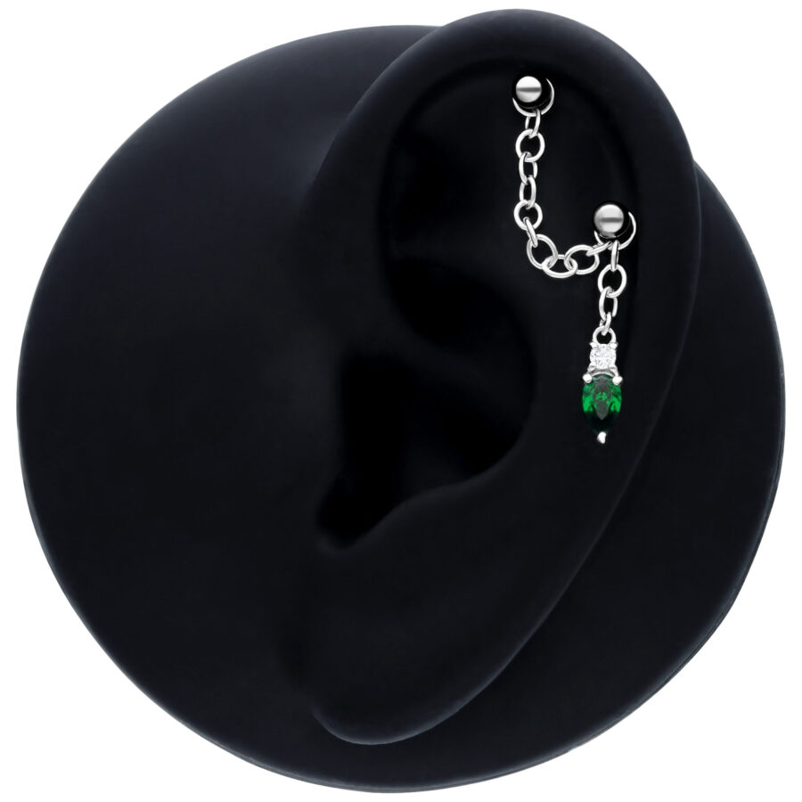 Schwarze Piercingkette mit smaragdgrünem Kristall an schwarzem Ohrmodell