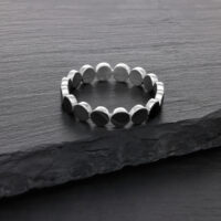 Silberner Ring aus Chirurgenstahl auf dunkler Steinoberfläche