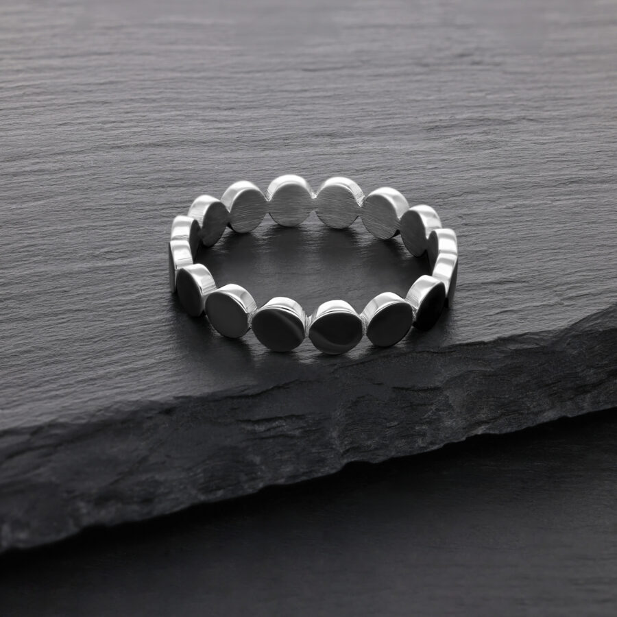 Silberner Ring aus Chirurgenstahl auf dunkler Steinoberfläche