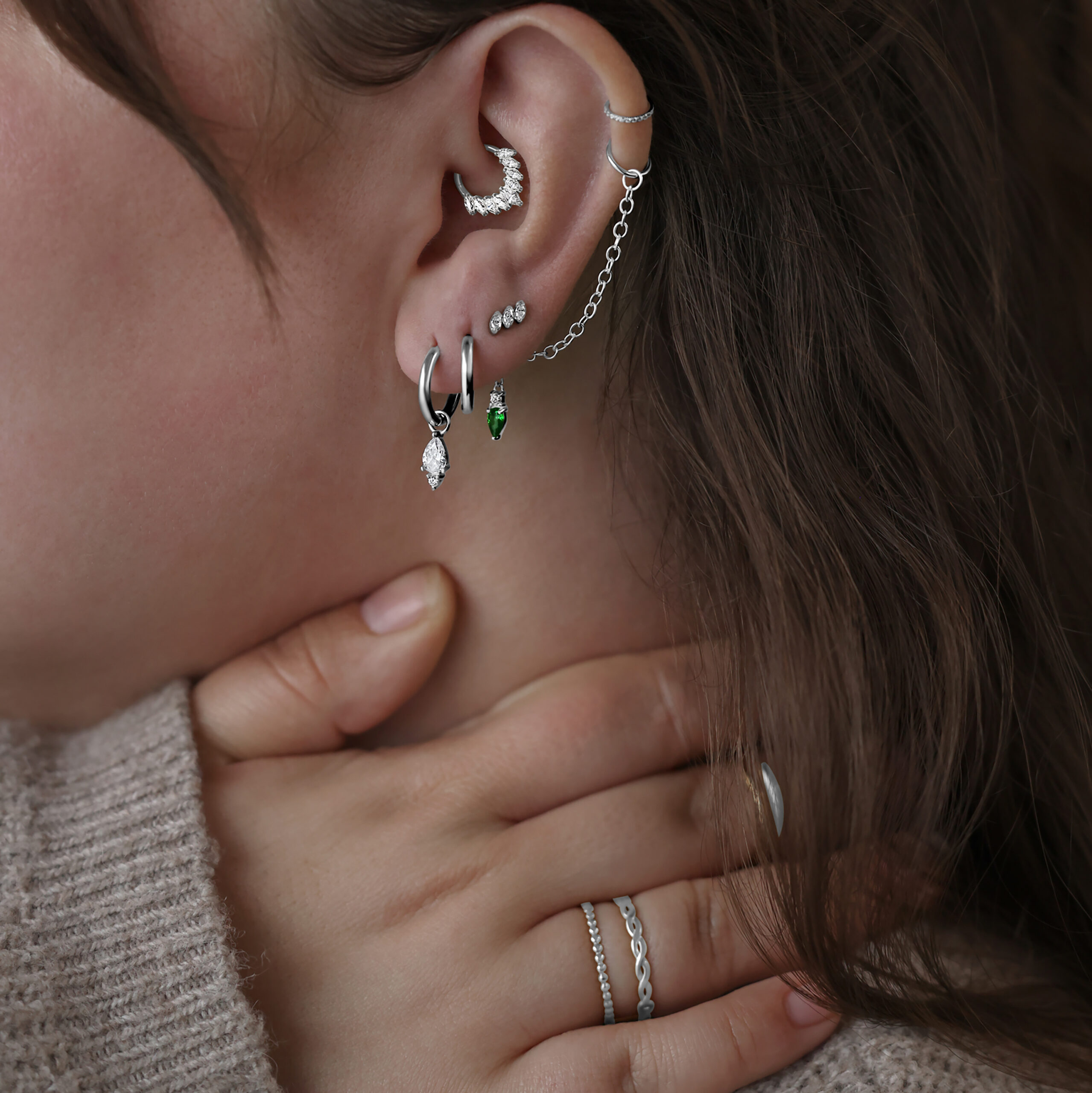 Gracia Aufsatz für Innengewinde aus Titan, Silber Frau mit mehreren silbernen Piercings am Ohr, darunter ein Gracia Aufsatz