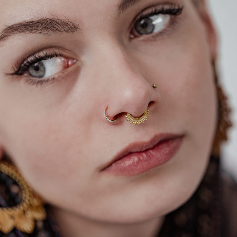 Frau mit goldenem Conch Ring und weißen Kristallen, Nahaufnahme