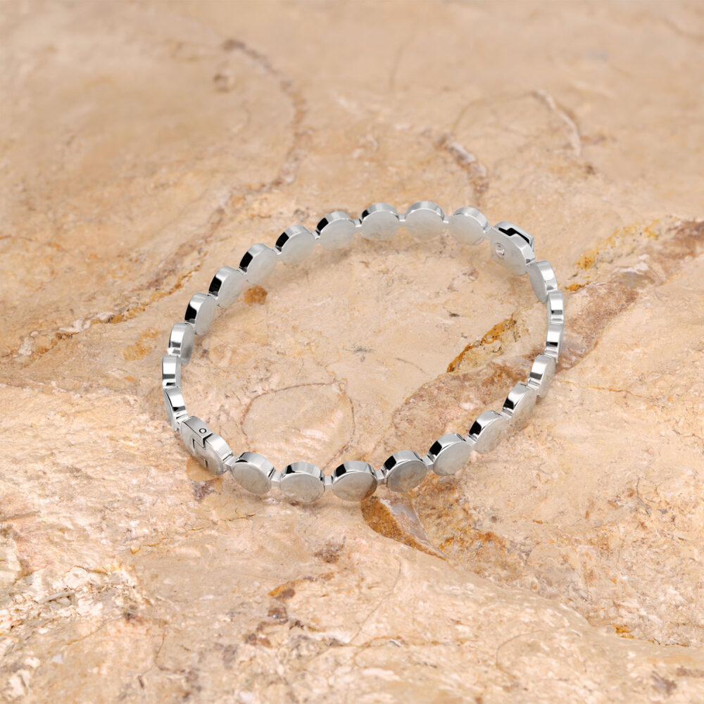 Silbernes Armband aus Chirurgenstahl auf einem beigen Steinuntergrund