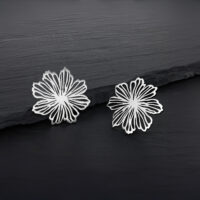 Feine Blumen Ohrstecker aus Edelstahl Zwei silberne Blumen Ohrstecker aus Edelstahl auf dunklem Hintergrund