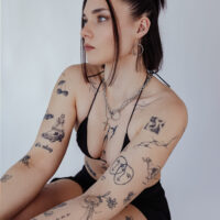 Goldene O Halskette aus Chirurgenstahl Frau mit goldener O Halskette aus Chirurgenstahl, Tattoos sichtbar