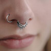 Triple Oriental Clicker in Silber für Septum Nahaufnahme eines silbernen Triple Oriental Clickers im Septum eines Gesichts
