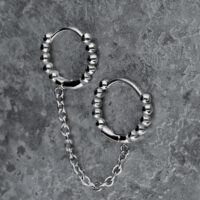 Silberne Doppel-Huggie-Ohrringe mit Kugeln und Kette auf grauem Hintergrund