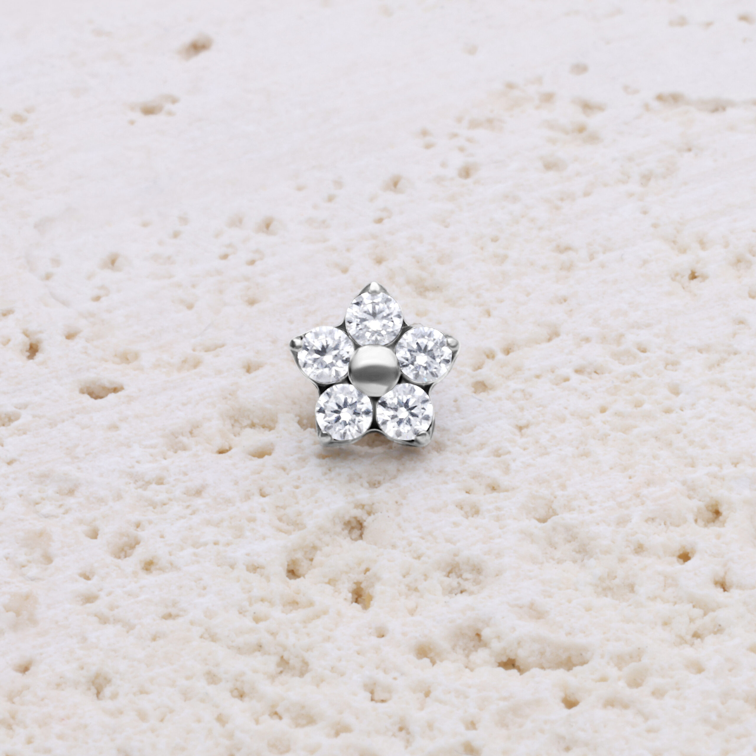 Glitzernder Blumenaufsatz aus Titan in Silber Silberner Blumenaufsatz mit Kristallen auf hellem Hintergrund