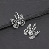 Zwei silberne Schmetterling Ohrhänger aus Edelstahl auf schwarzem Hintergrund