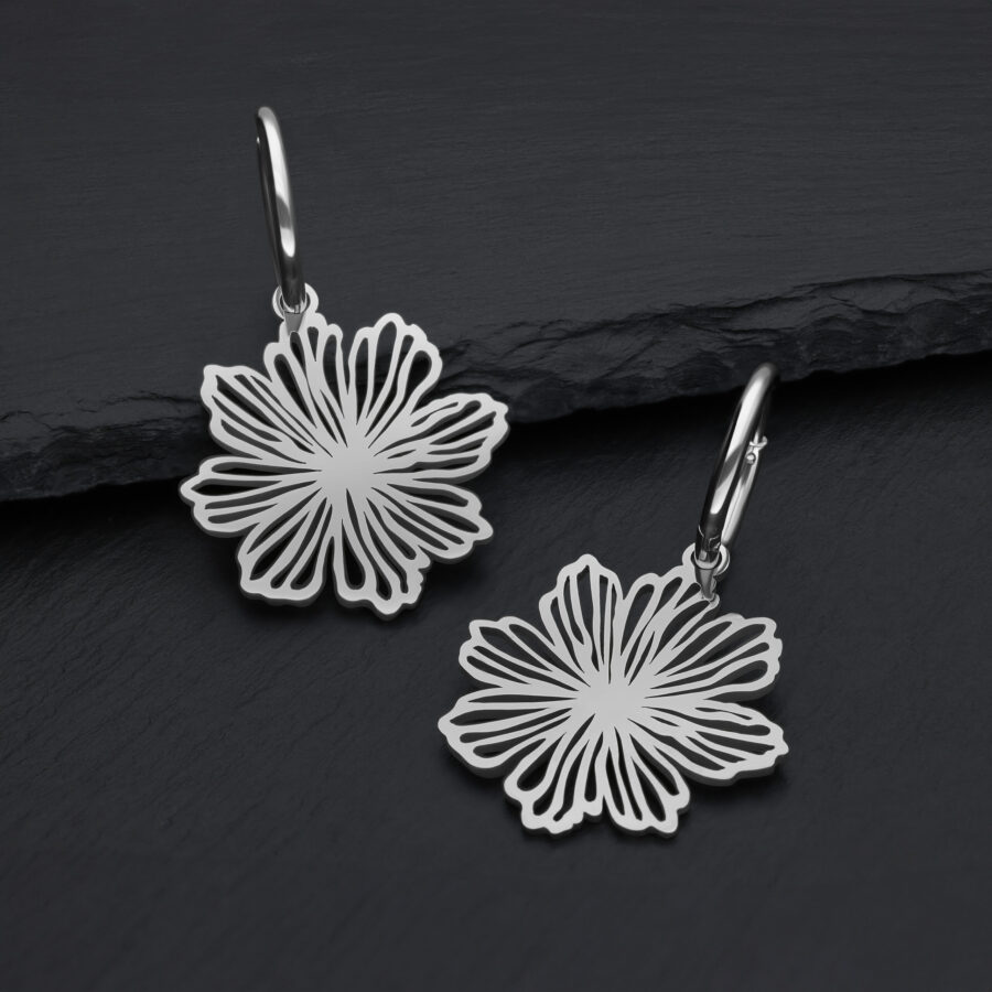 Silberne Edelstahl-Ohrringe mit Blumendesign auf dunklem Hintergrund