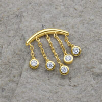 Goldener Piercing-Aufsatz mit fünf klaren Kristalltropfen auf grauem Hintergrund