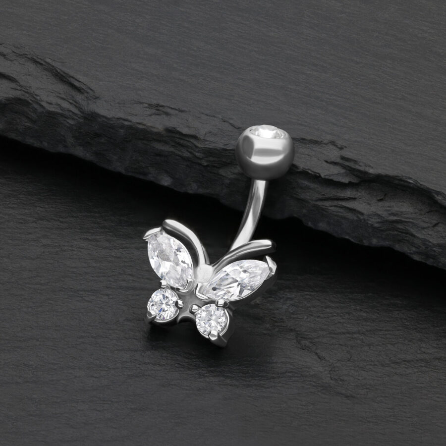 Silbernes Bauchnabelpiercing mit Schmetterling und klaren Kristallen auf schwarzem Hintergrund