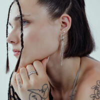 Stylische Little Rockin' Triangle Ohrstecker Frau mit schwarzen Haaren trägt silberne Triangle Ohrstecker