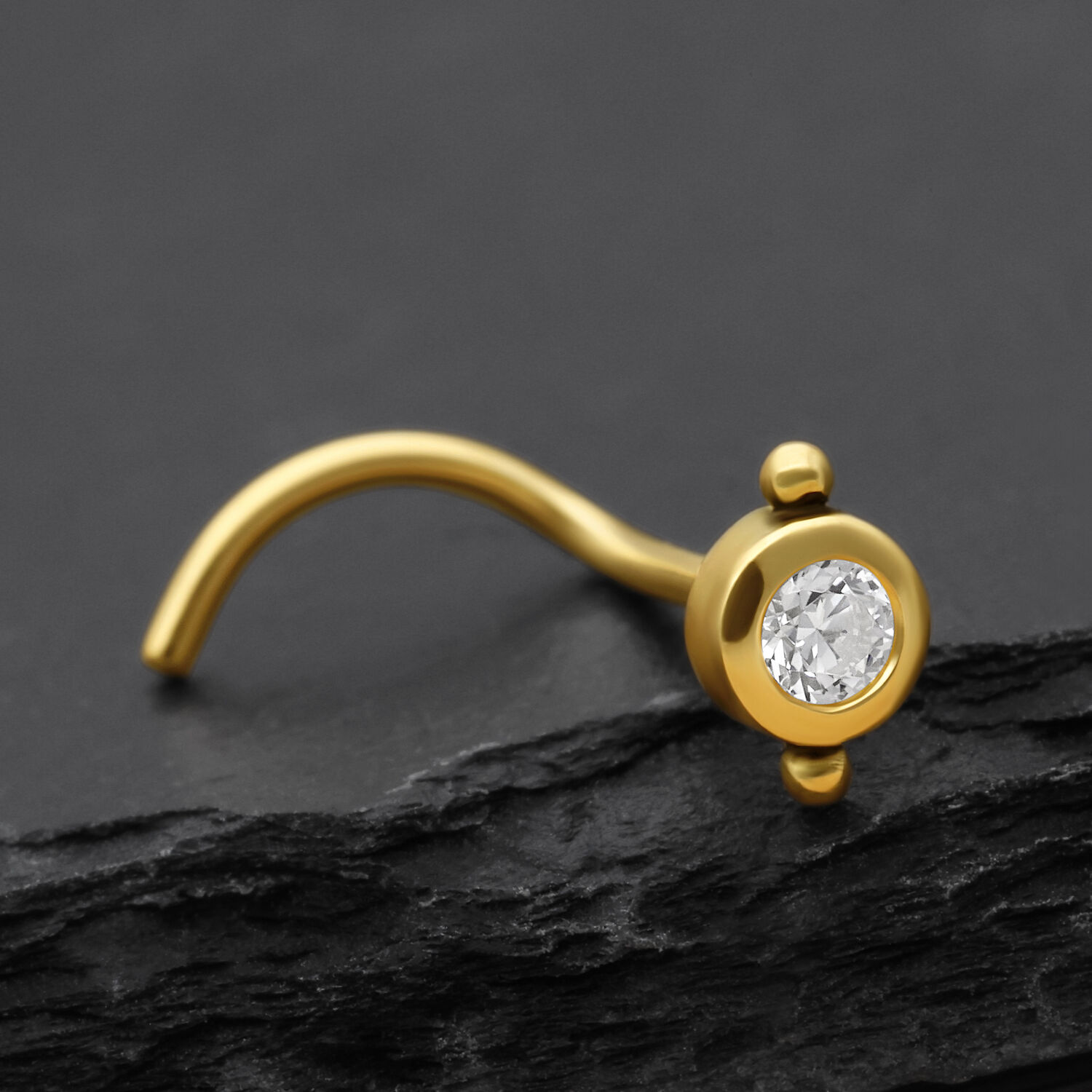 18K Gold Nasenstecker mit Kristall Goldener Nasenstecker mit klarem Kristall auf dunklem Hintergrund