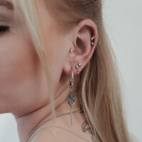 Push Fit Kristall Stern Aufsatz am Ohr Nahaufnahme eines Ohres mit mehreren Piercings, darunter ein großer, silberner Push Fit Kristall Stern Aufsatz.