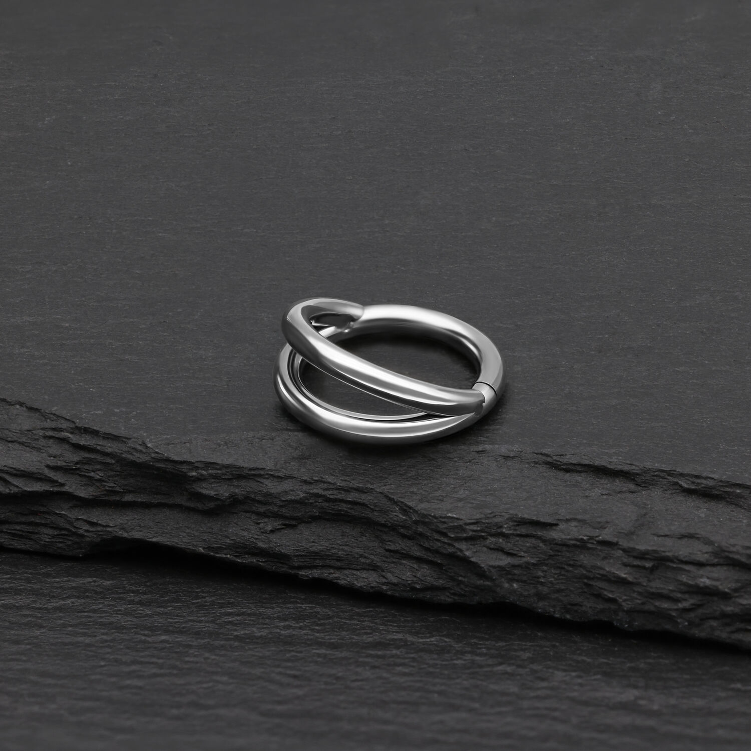 Doppelreihiger Silber Clicker Piercing Ring Silberner doppelreihiger Clicker Ring aus Titan auf schwarzem Hintergrund