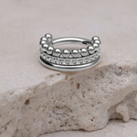 Triple Bubble Crystal Clicker aus Titan Silberner Triple Bubble Crystal Clicker auf hellem Stein