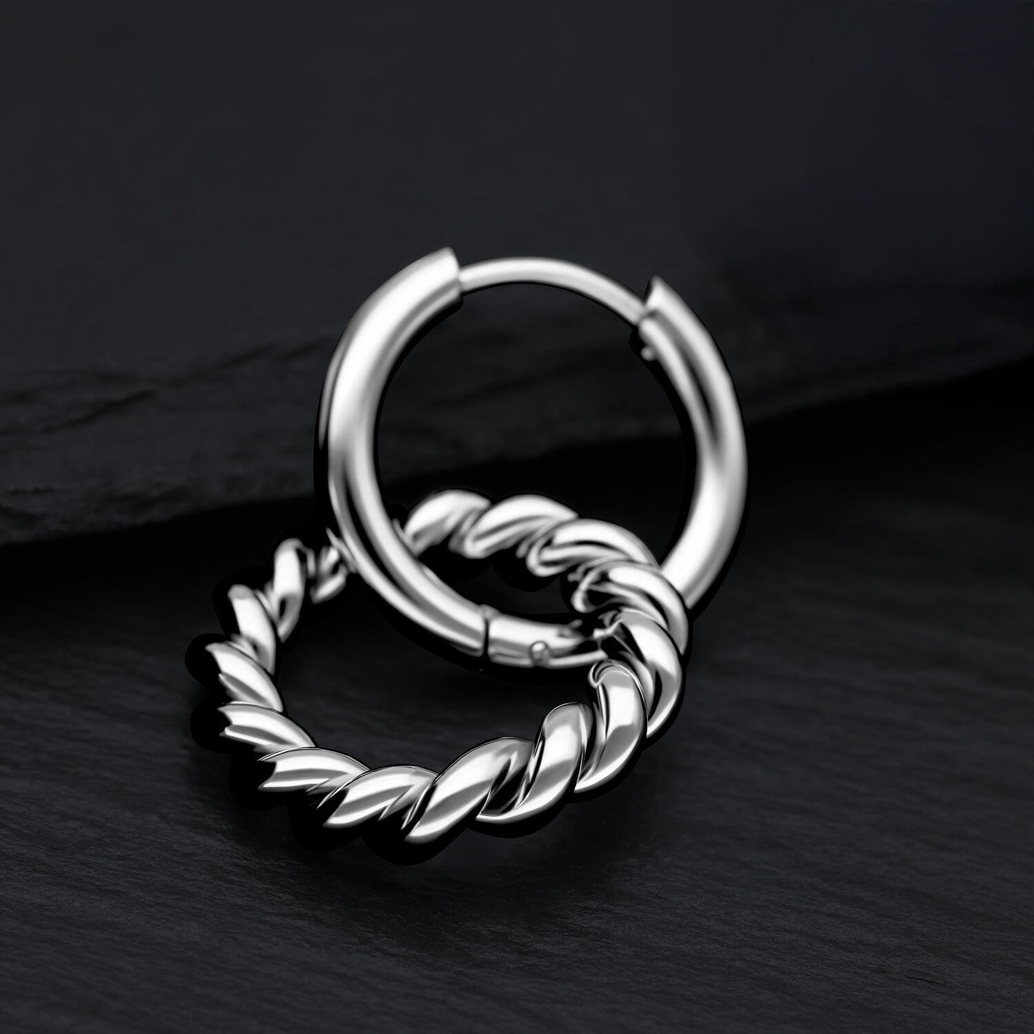 Elegante Twisted Circle Hoops aus Edelstahl Silberne Twisted Circle Hoops aus Edelstahl auf schwarzem Hintergrund