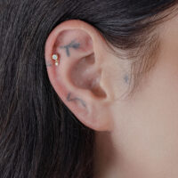 14K Gold Doppel-Kristall Piercing Aufsatz Goldener Aufsatz mit zwei Kristallen am Ohr getragen, Nahaufnahme