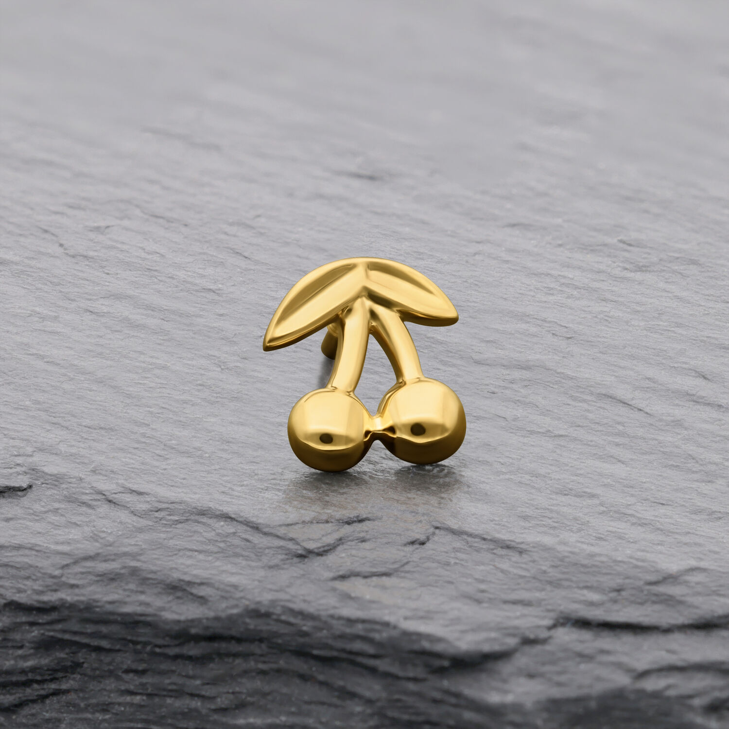 14K Gold Kirsche Aufsatz für Piercings Goldener Kirschenaufsatz aus 14K Gold auf grauem Hintergrund