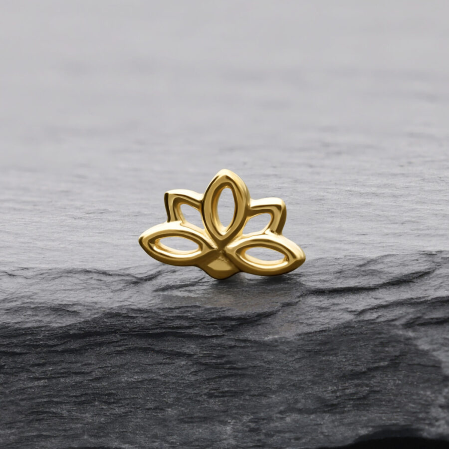 Goldener Lotus Aufsatz auf grauem Stein mit klaren Linien und glänzender Oberfläche